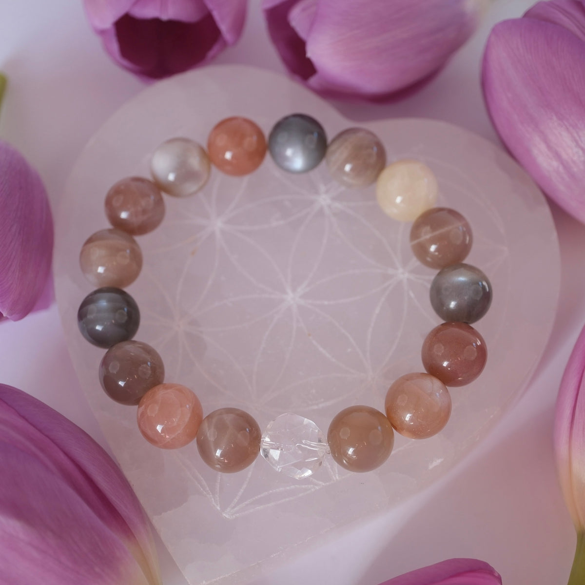 Luminous Moonstone bracelet surrounded by flowers to show its beauty and grace