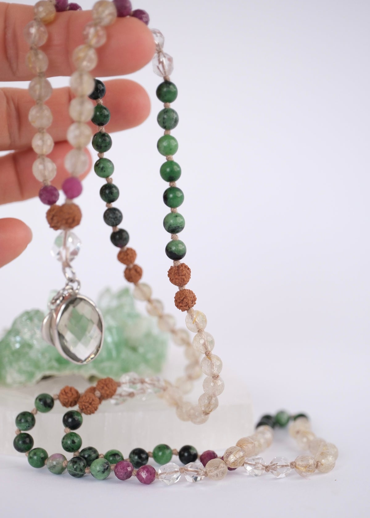 Green and red ruby zoisite prayer mala for life force, vitality, and awakening, threaded with golden rutilated quartz and clear Herkimer light with Close view of the faceted lemon quartz pendant