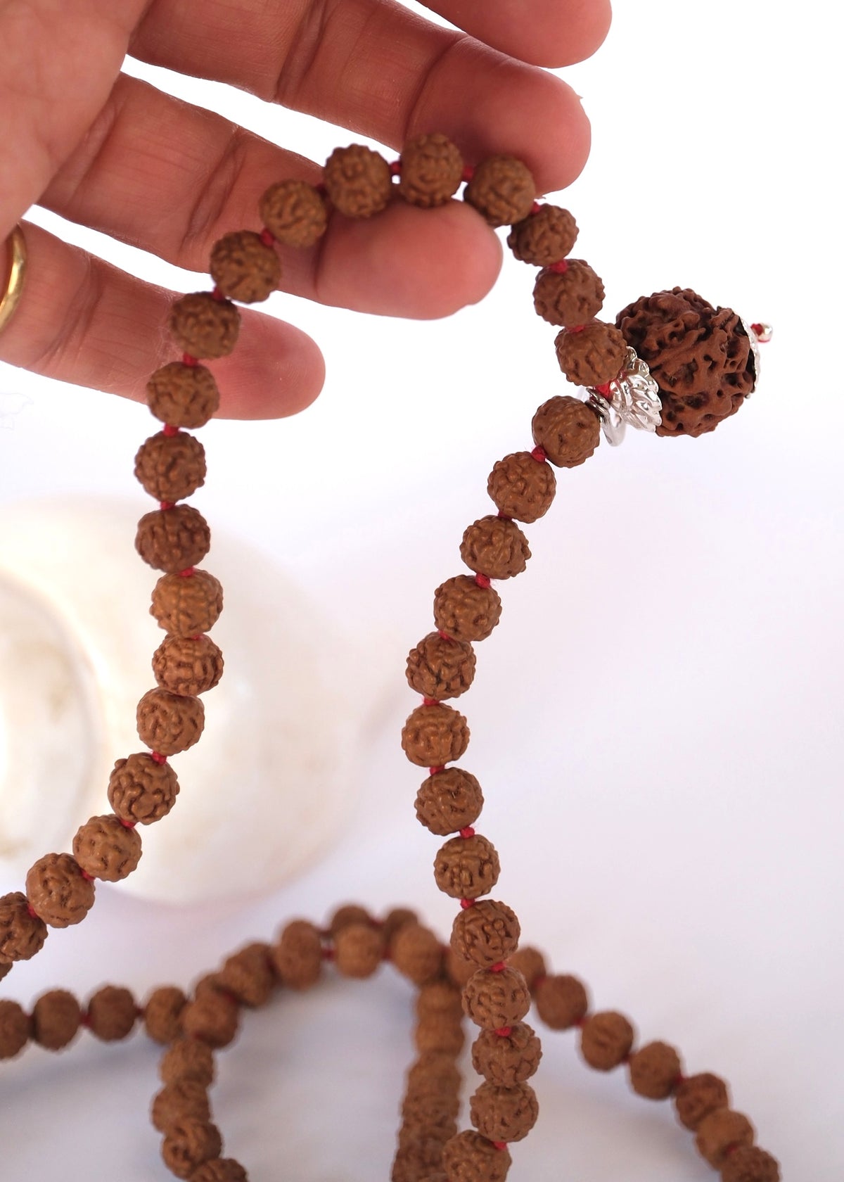 Hands moving across the 108-bead Nepal Rudraksha Japa Mala during daily mantra meditation.