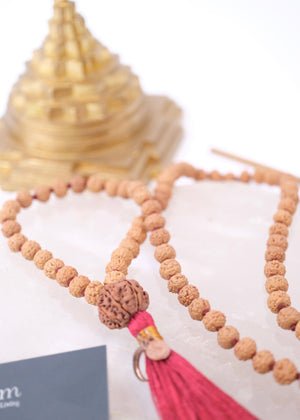 Rudraksha mala necklace with authentic red colour tassel and Sri Yantra on a white background