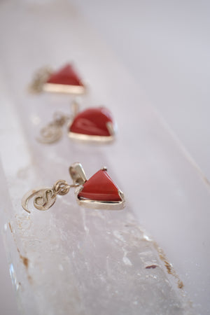 Close view of a deep red Italian coral Mars pendant with crescent moon and S Shivoham charms.
