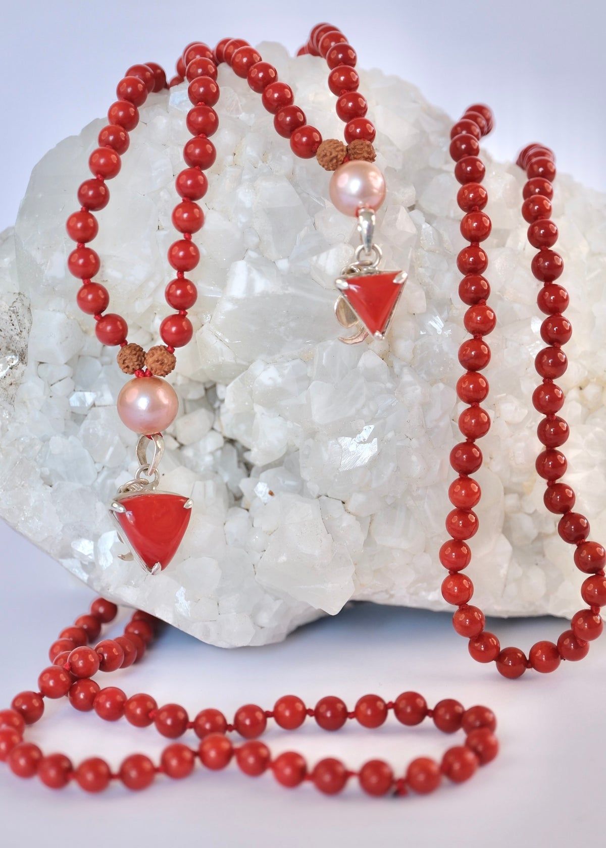 Small and large Italian red coral Moonga pendants shown side by side
Moonga Mala in two pendant sizes, the smaller and larger red coral Mars forms