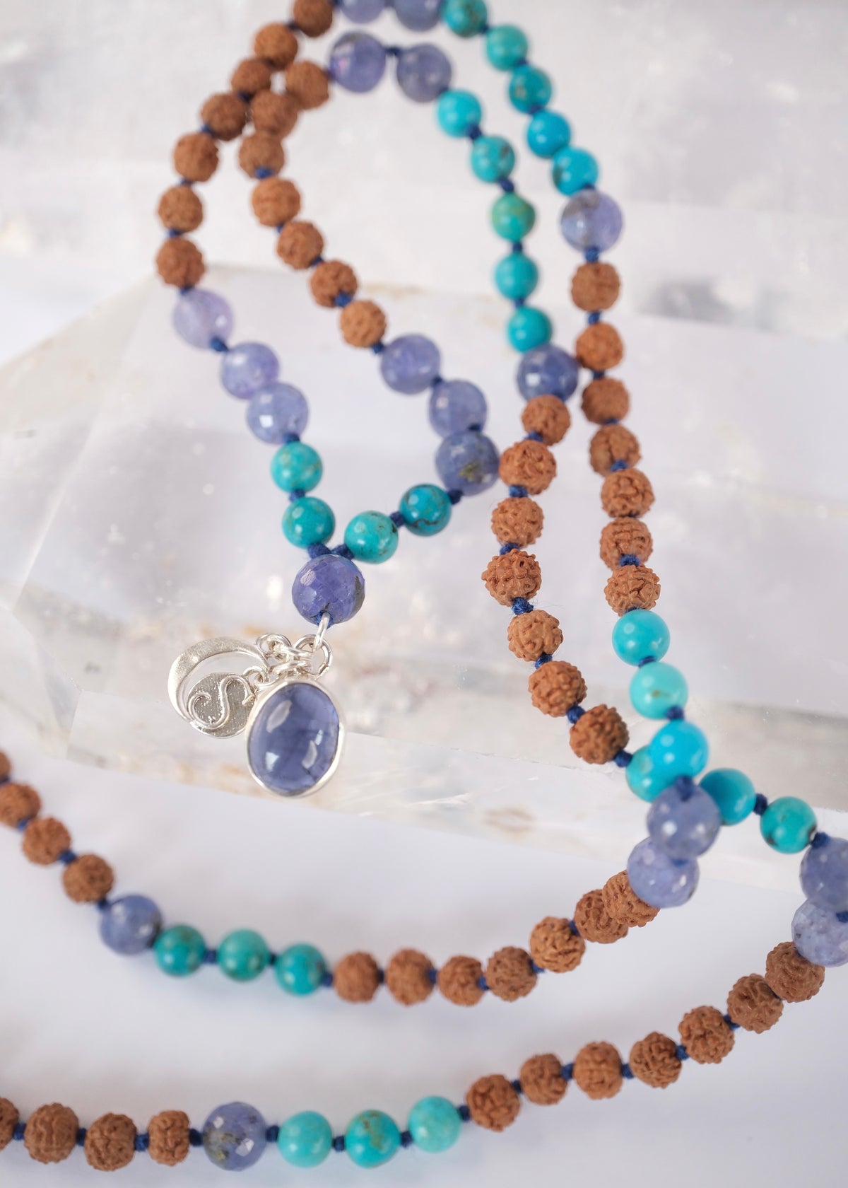 Close view of the premium iolite pendant and faceted tanzanite beads on the Divya Chakshu awakened seer mala.