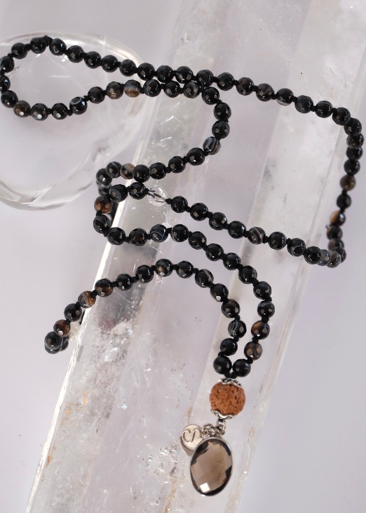 Vajra mala of faceted black onyx with a smoky quartz pendant and Rudraksha, for strength, protection, and the power to push through.