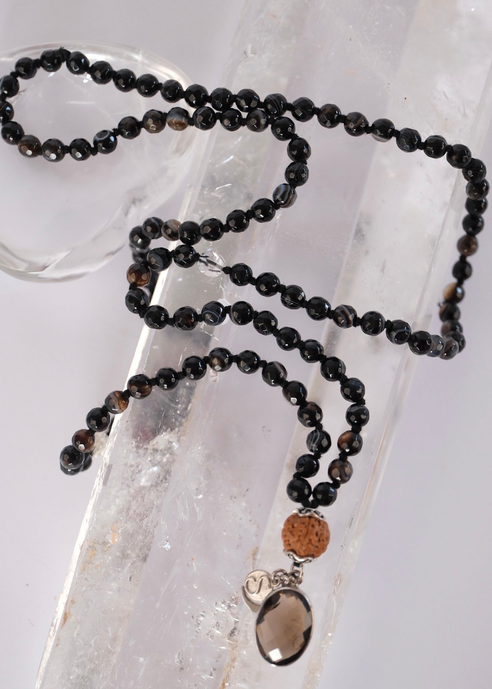Vajra mala of faceted black onyx with a smoky quartz pendant and Rudraksha, for strength, protection, and the power to push through.