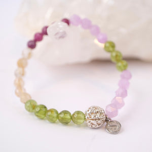 Beaded bracelet with a silver clasp on a white shell background