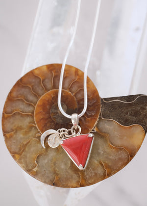 Close view of a deep red Italian coral Mars pendant with crescent moon and S Shivoham charms.