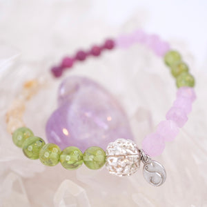 Beaded bracelet with a silver clasp on a white shell background