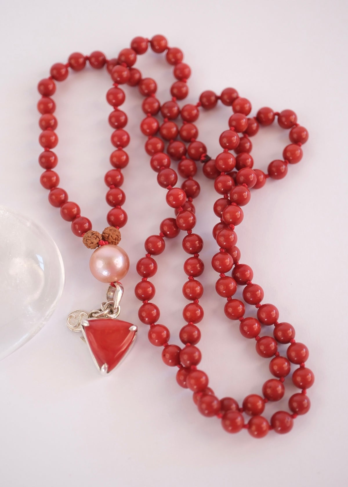 Complete red coral Moonga Mala with Italian coral pendant and Akoya pearl guru bead
Handcrafted red coral Mars mala laid full length with triangular Moonga pendant