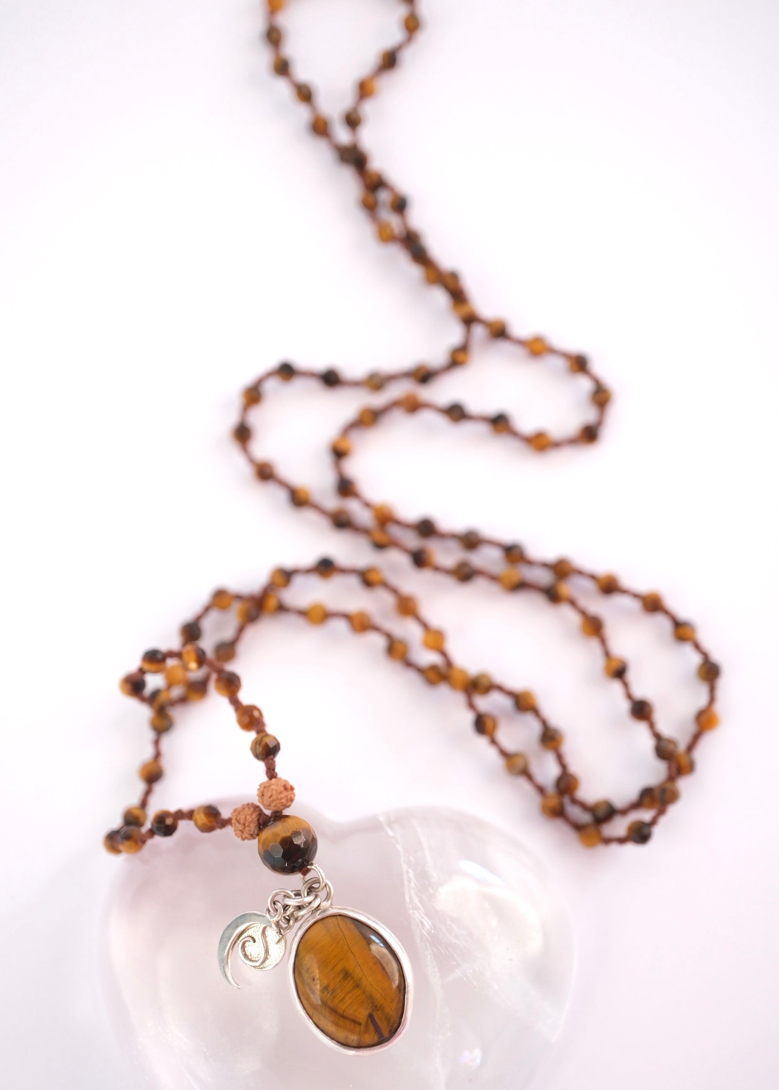 Faceted tiger’s eye beads with Rudraksha above the guru bead on the solar clarity mala