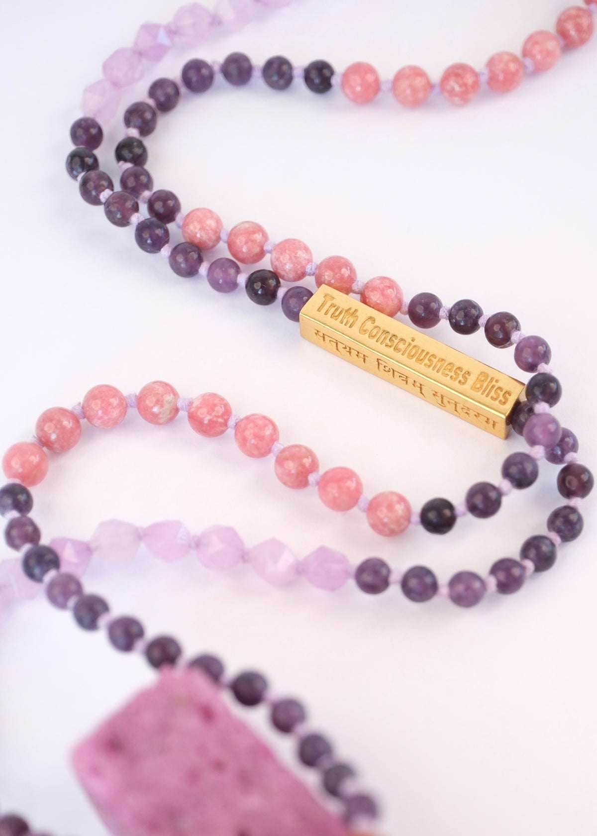 Beaded necklaces with a gold tag on a white background