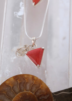 Close view of a deep red Italian coral Mars pendant with crescent moon and S Shivoham charms.