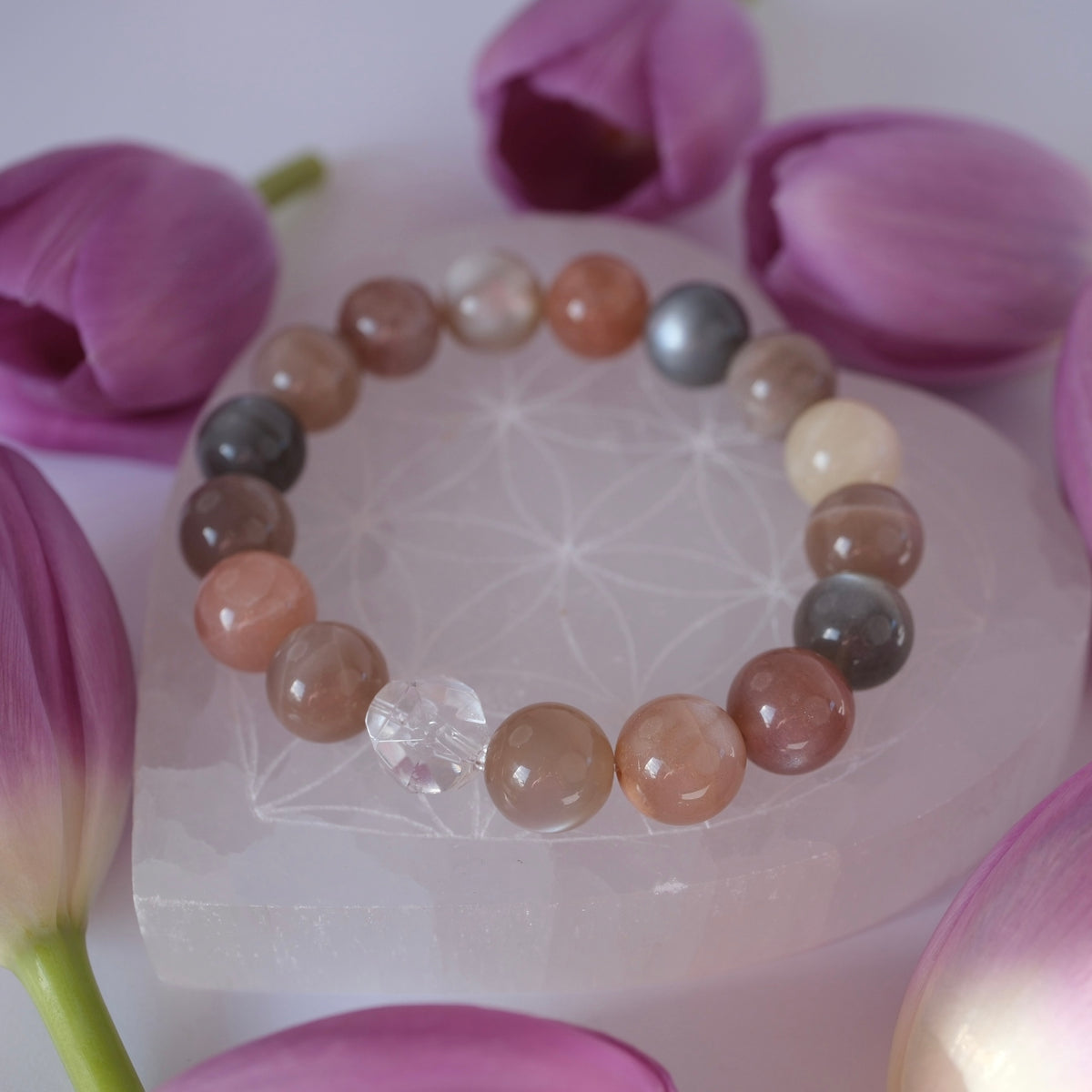Rainbow of moonstone tones with clear Herkimer, a bracelet of gentle magic and the divine feminine. Surrounded by tulips