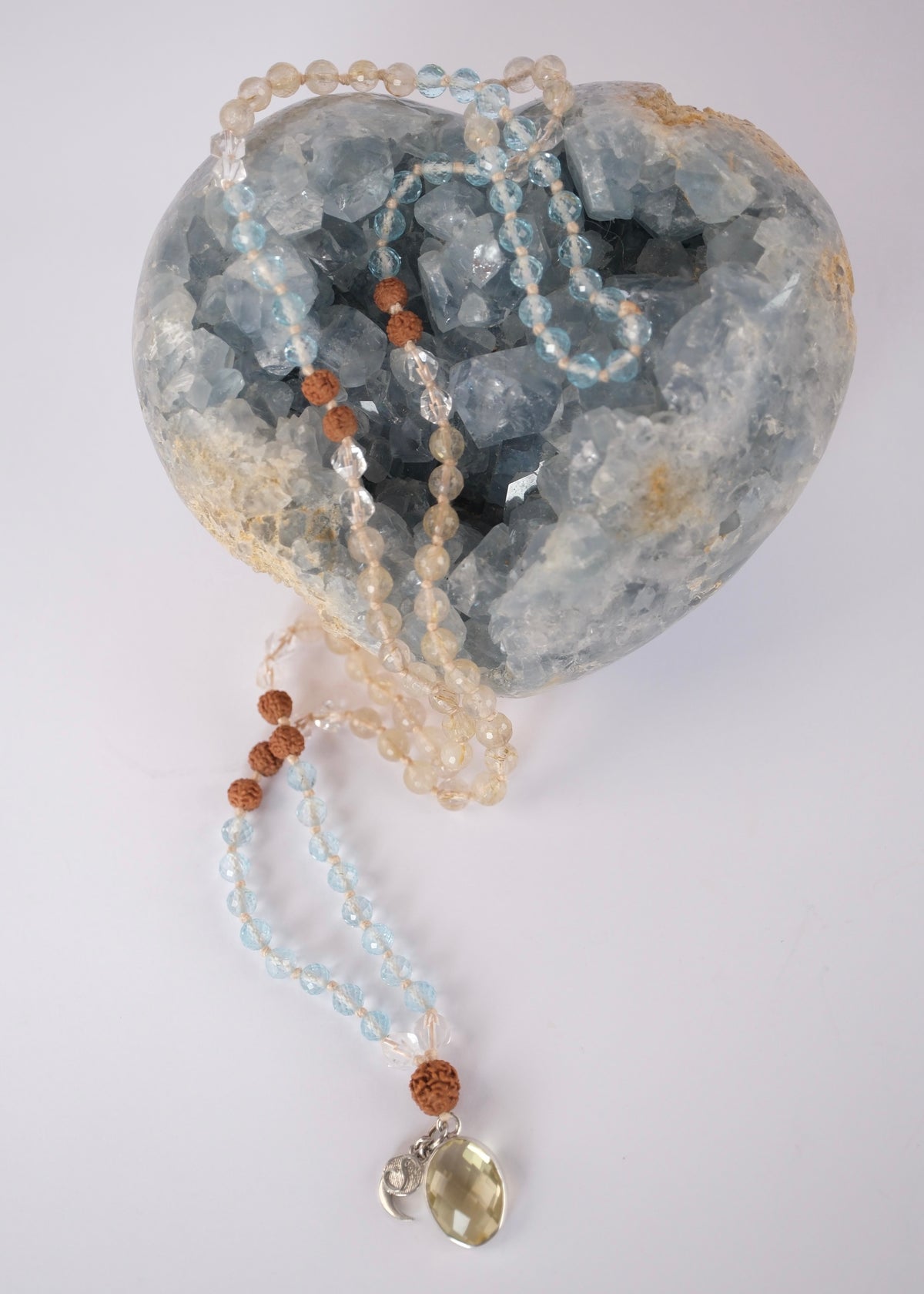Handcrafted blue topaz and lemon quartz mala with Rudraksha and a faceted lemon quartz pendant, knotted with mantra and blessed by Ma Ganga.