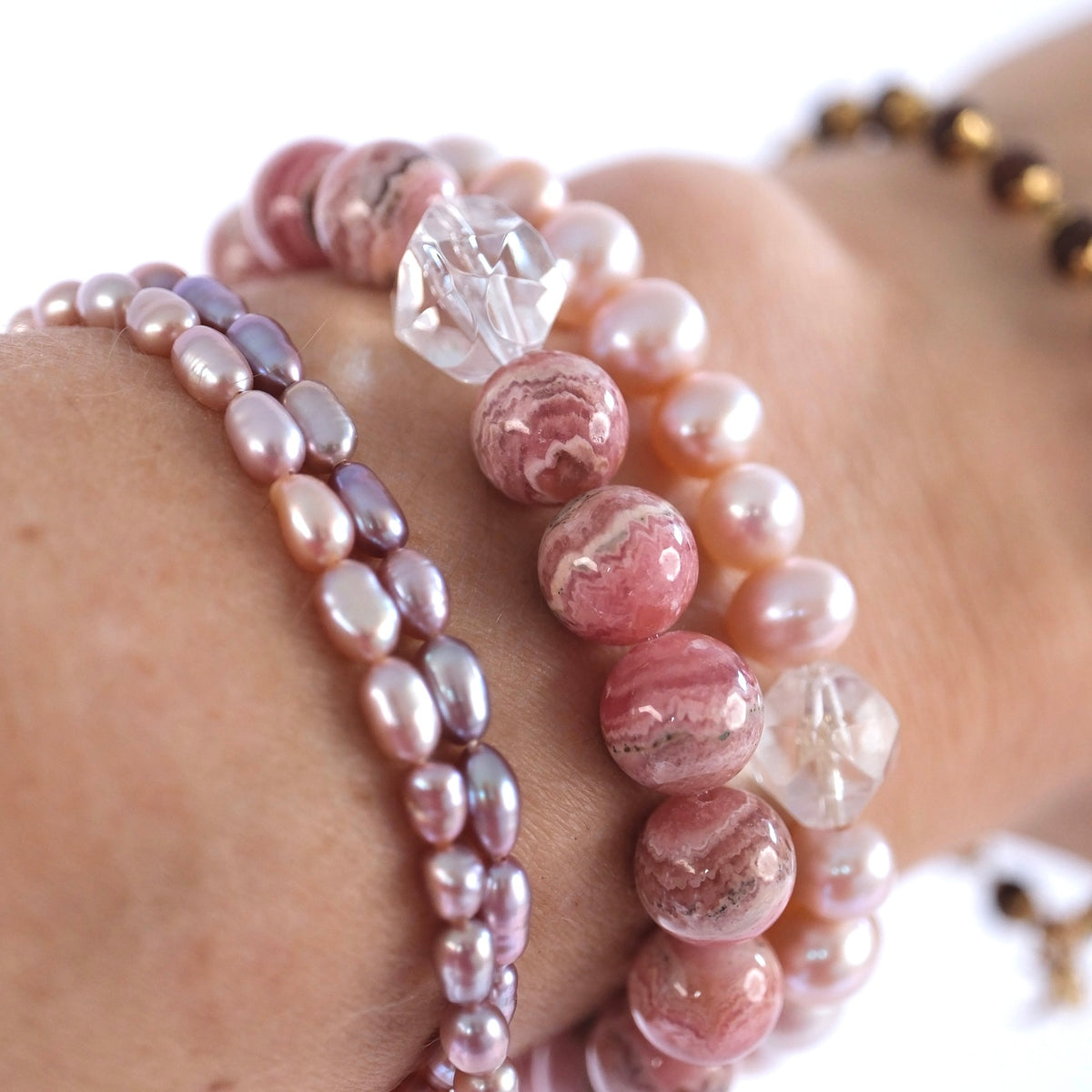 Superior 10mm rhodochrosite crystal bracelet for self love, joy, and emotional healing, worn at the wrist.