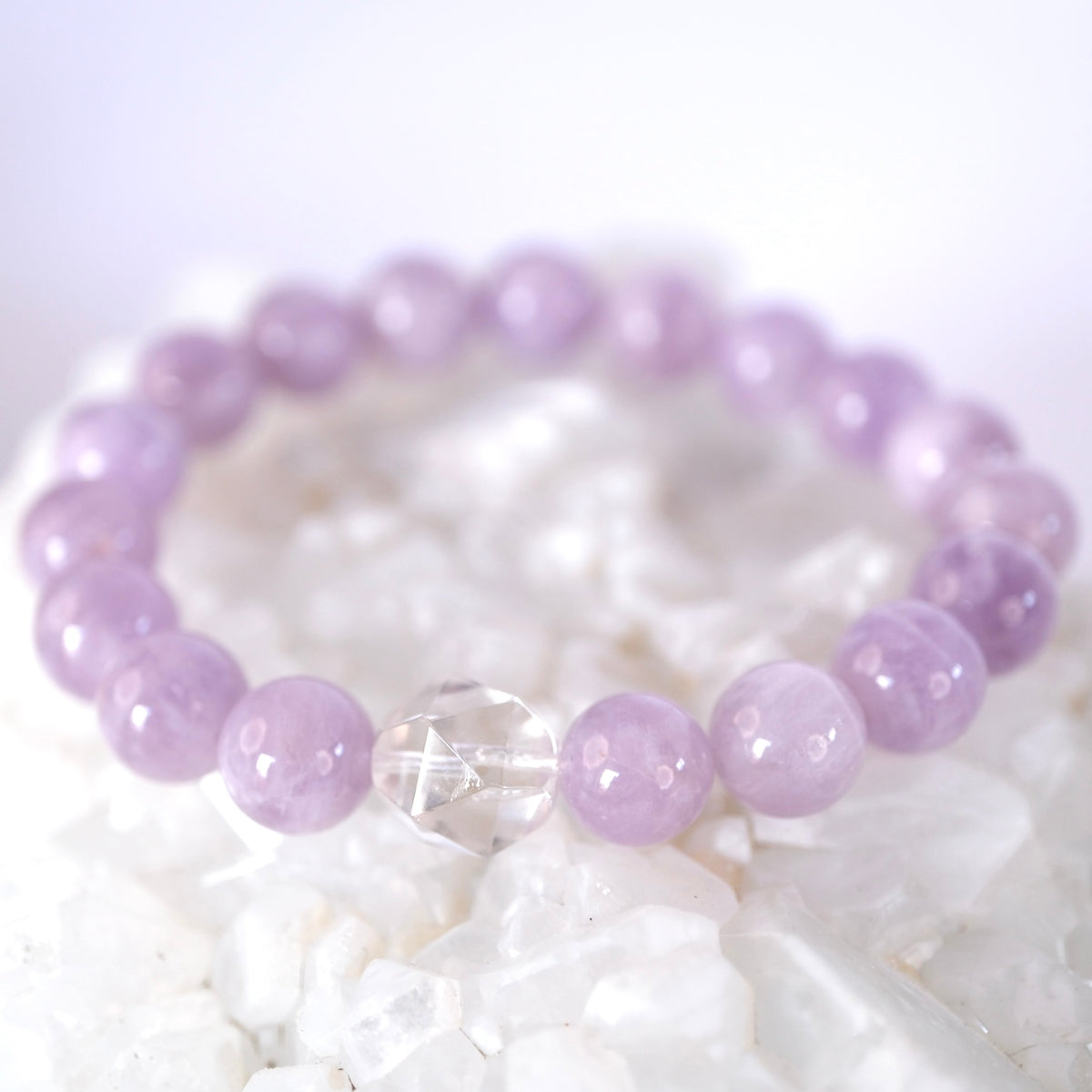 Dreamy lavender quartz bracelet resting on quartz, the nectar of peace and quiet grace.