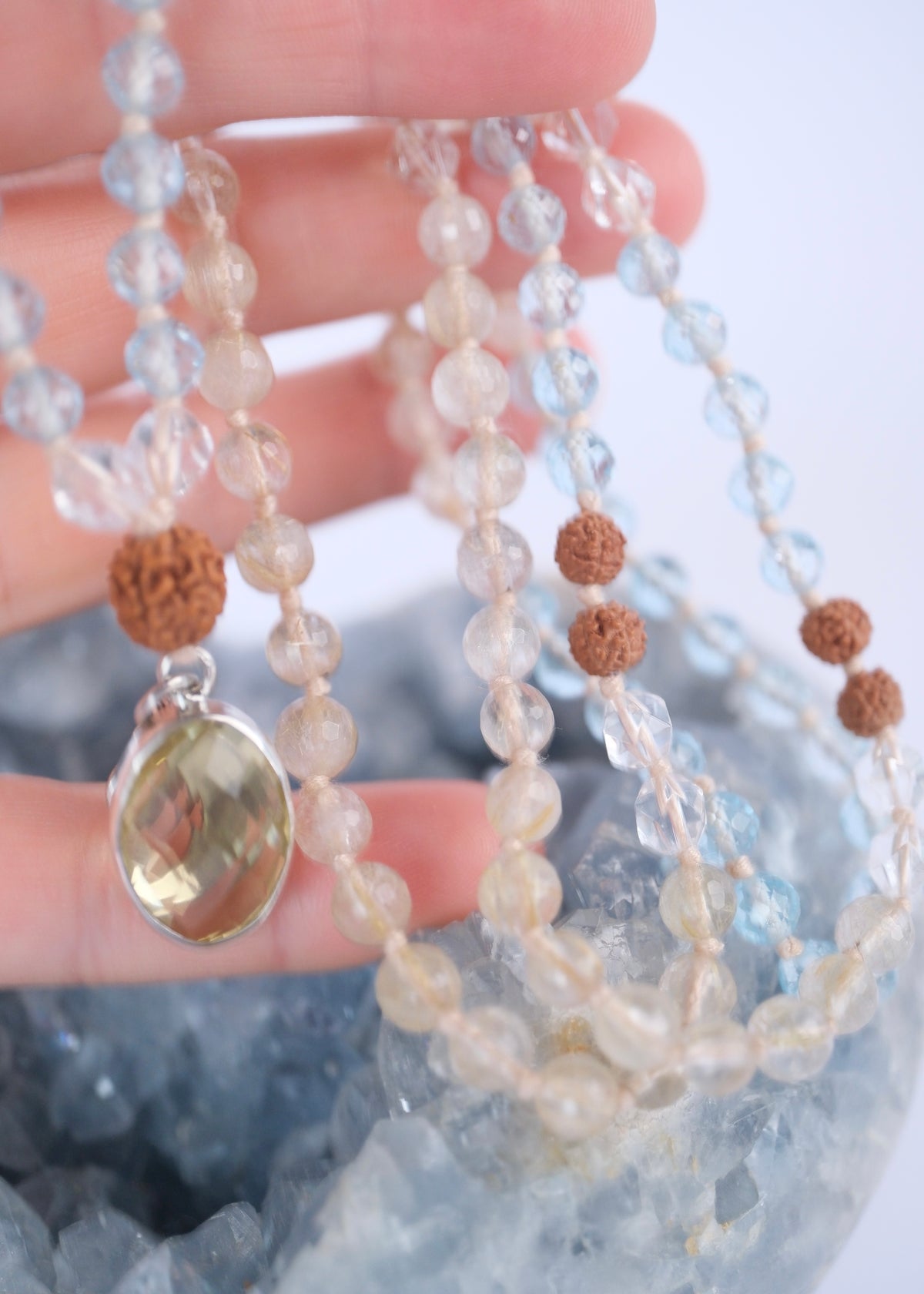 Close view of the faceted lemon quartz pendant with crescent moon and S