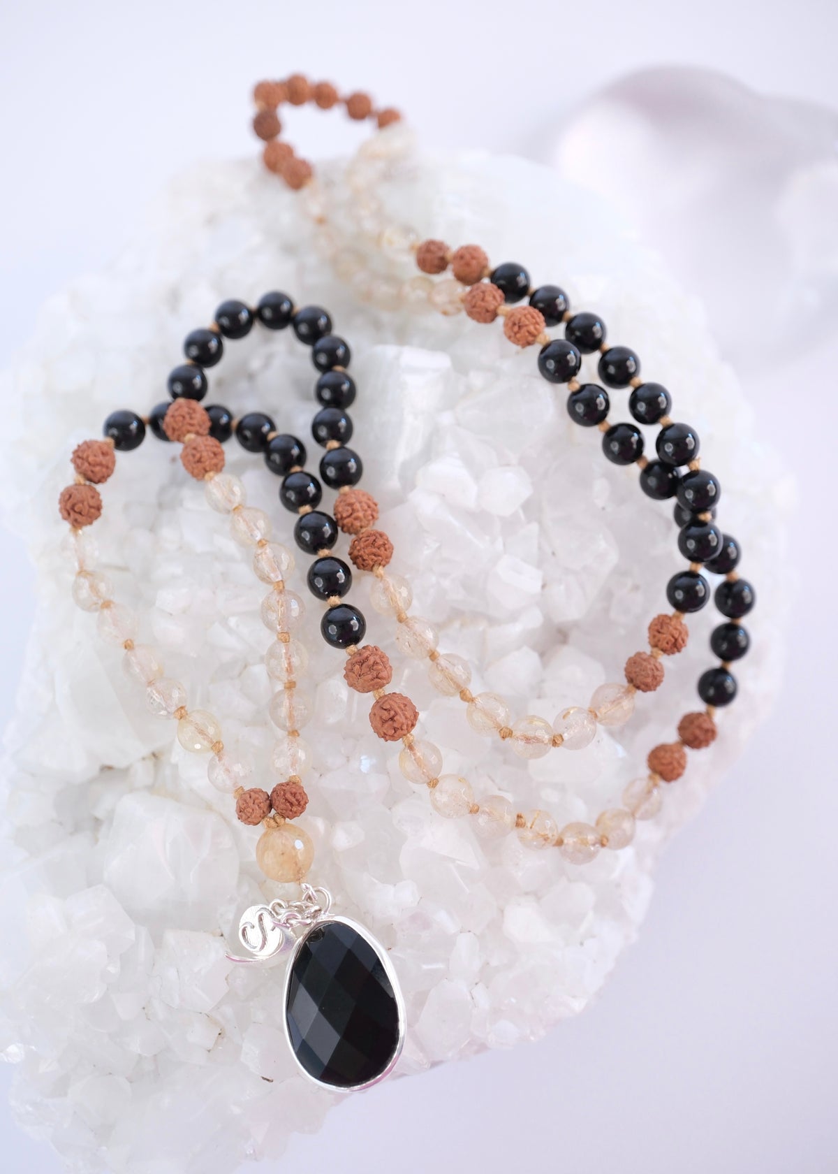 Tantrika mala with faceted black tourmaline pendant and golden rutilated quartz beads, Double sided faceted black tourmaline pendant set in sterling silver with Shivoham charms