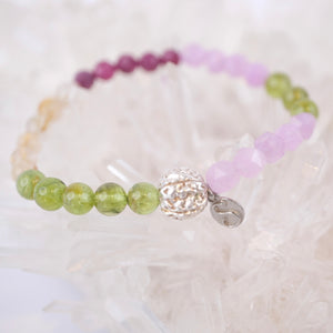 Beaded bracelet with a silver clasp on a white shell background