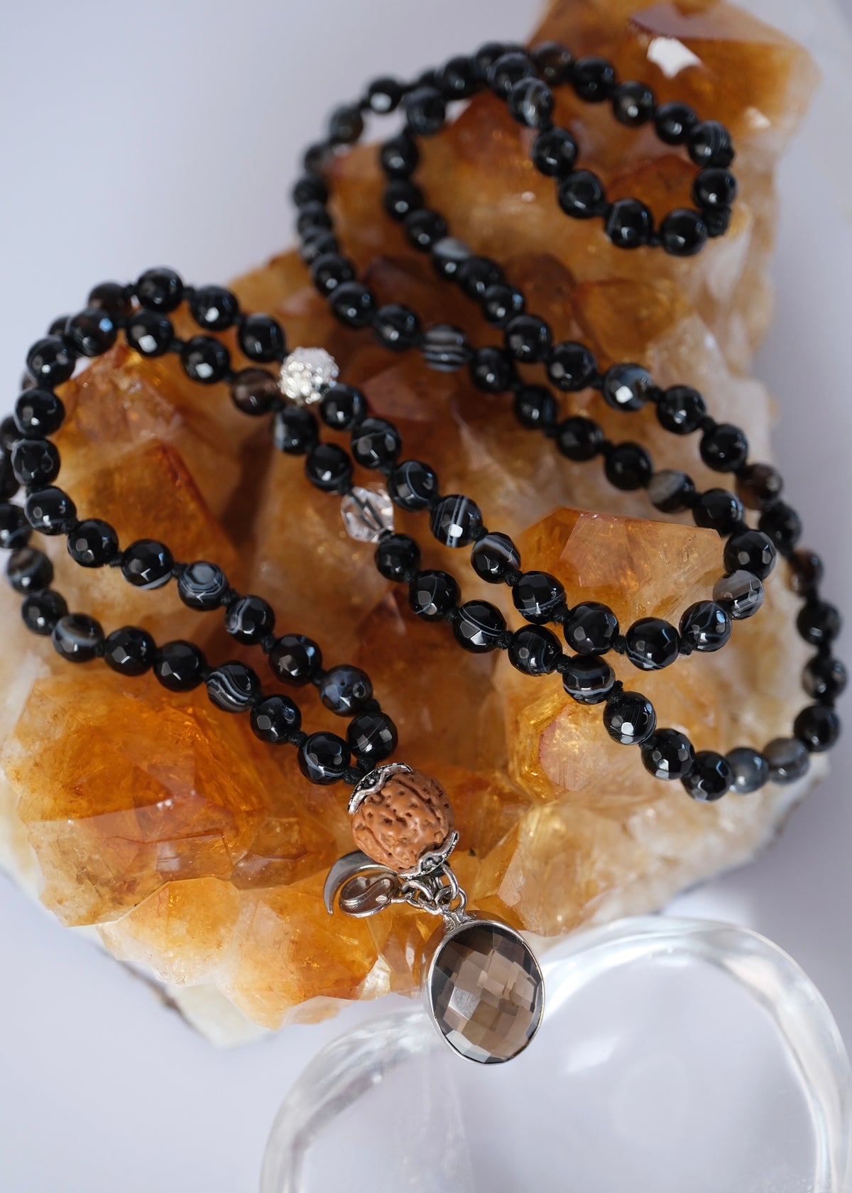 Black onyx and smoky quartz japa mala for endurance and breakthrough, grounded with sacred Rudraksha.