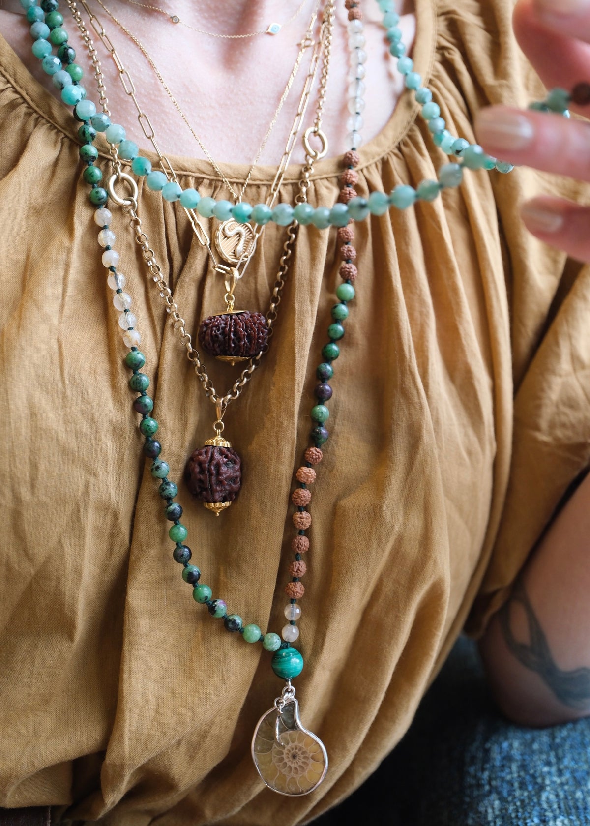 Spiritual Jewellery on woman wearing brown top. Looking Divine