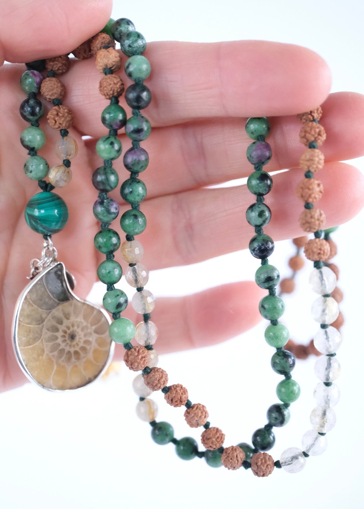Ammonite pendant, Malachite guru bead and ruby zoisite beads on a Rudraksha seer’s mala