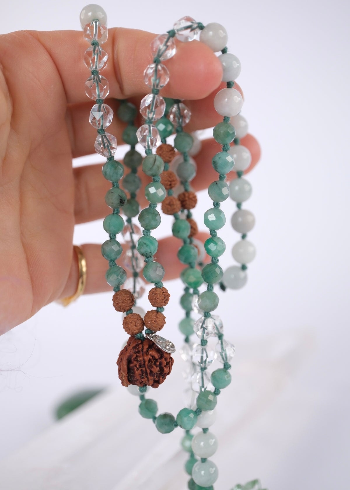 Handcrafted green jade and emerald mala with Rudraksha and a Ganesh guru bead, knotted with mantra and blessed by Ma Ganga. The Riddhi jade and emerald mala