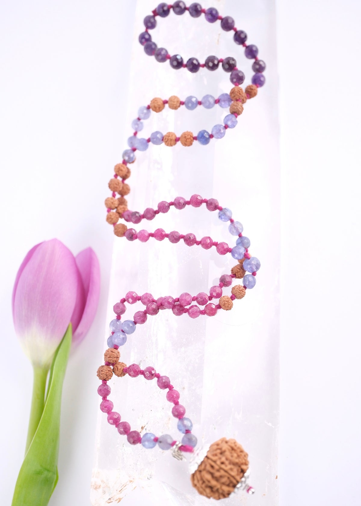 Nepali nine mukhi Rudraksha guru bead with sterling silver caps on the Durga mala
Faceted ruby and tanzanite beads on a handcrafted divine feminine mala