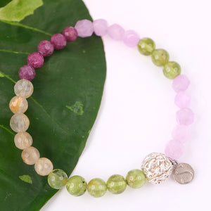 Beaded bracelet with a silver clasp on a white shell background