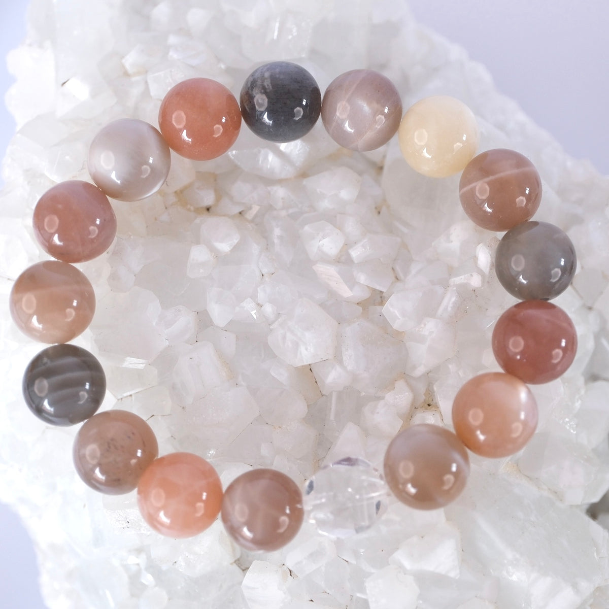 Chandra Kala bracelet of 12mm moonstone in peach, grey, cream, and rose hues with a Herkimer diamond, for intuition and calm.