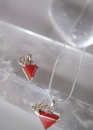 Close view of a deep red Italian coral Mars pendant with crescent moon and S Shivoham charms.