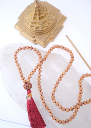 Rudraksha mala necklace with authentic red colour tassel and Sri Yantra on a white background