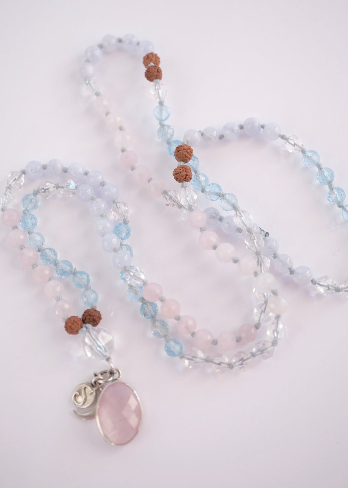 Prema Shanti mala with faceted rose quartz pendant and topaz and Herkimer beads. Double sided faceted rose quartz pendant