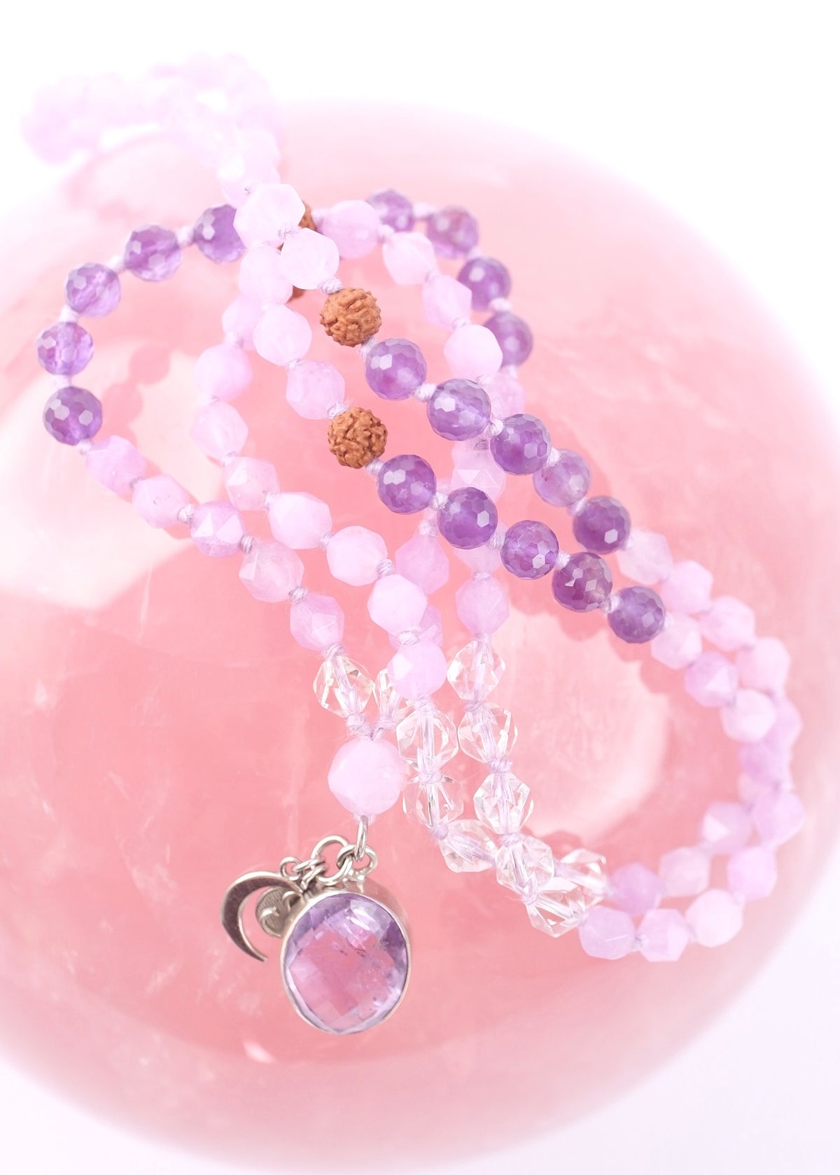 Set of beaded necklace mala beads with a pink stone pendant on a pink background
