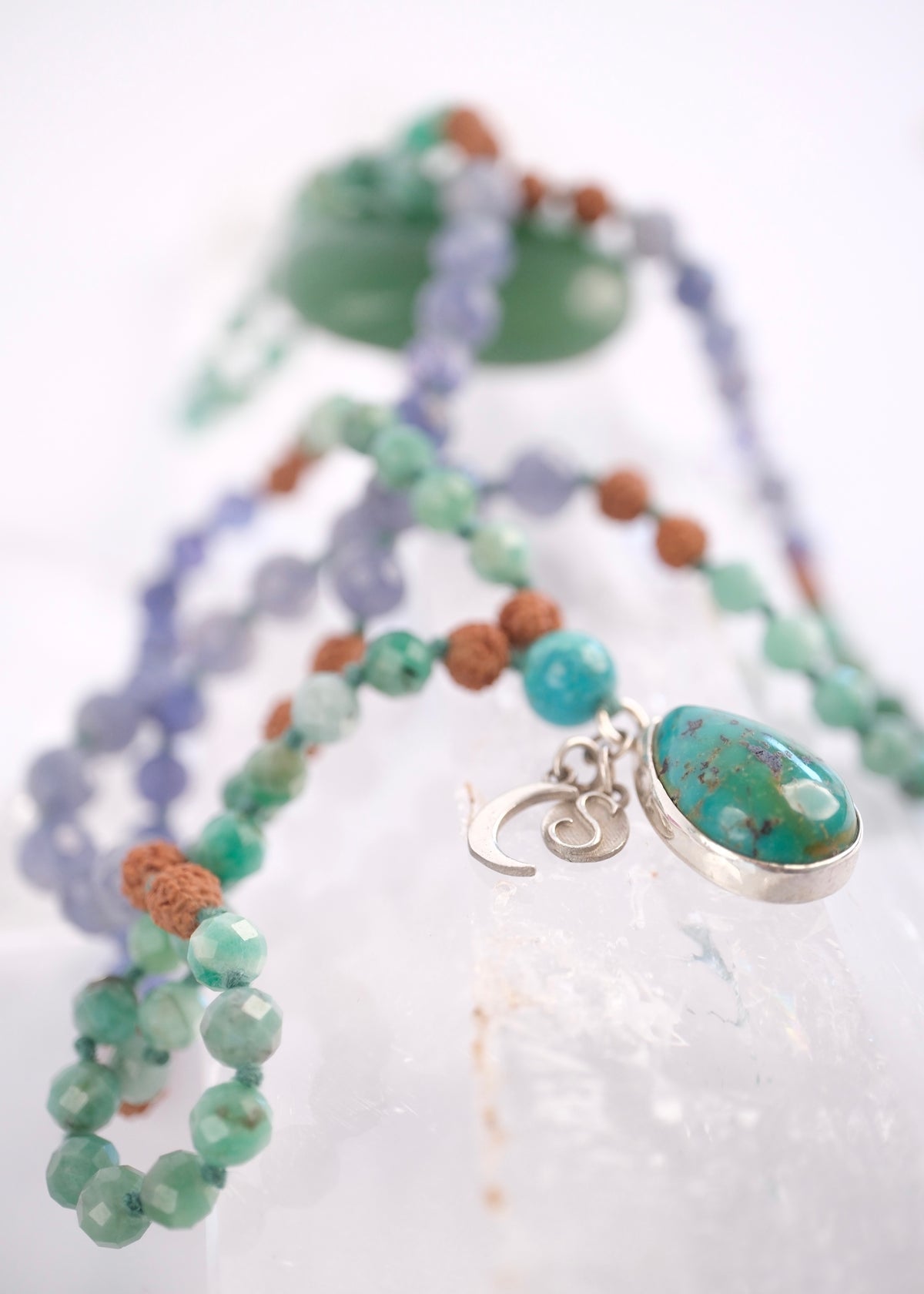 Persian turquoise guru bead on a faceted emerald and tanzanite success mala
