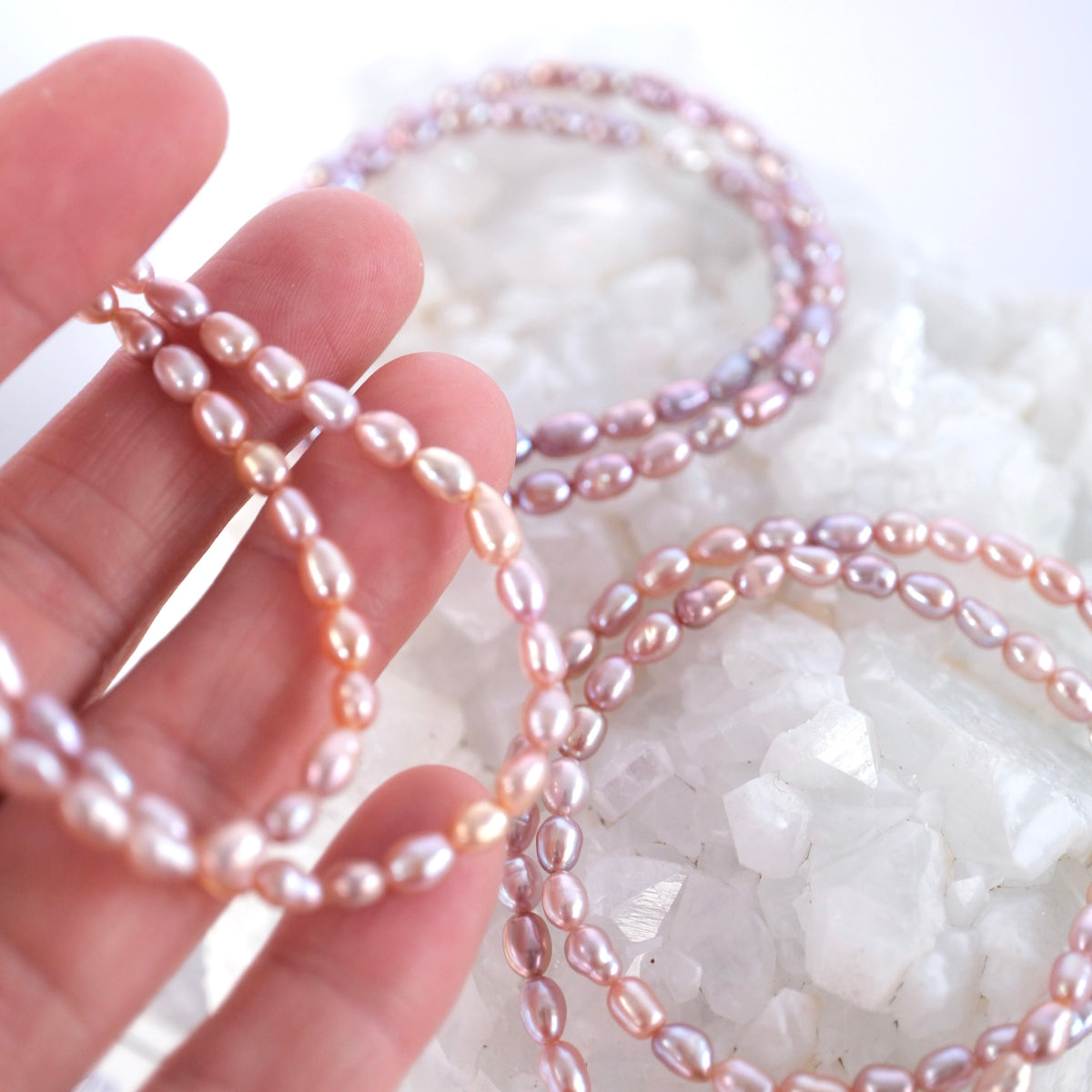 Close view of shimmering pink, purple, and apricot Akoya pearls on the Grace of the Moon bracelet.