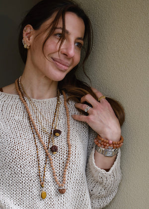 Shivoham Premium collector's Rudraksha japa mala for courage, wisdom, focus, and clarity, finished with sterling silver caps and charms. Authentic Nepal Rudraksha mala resting on clear quartz crystal