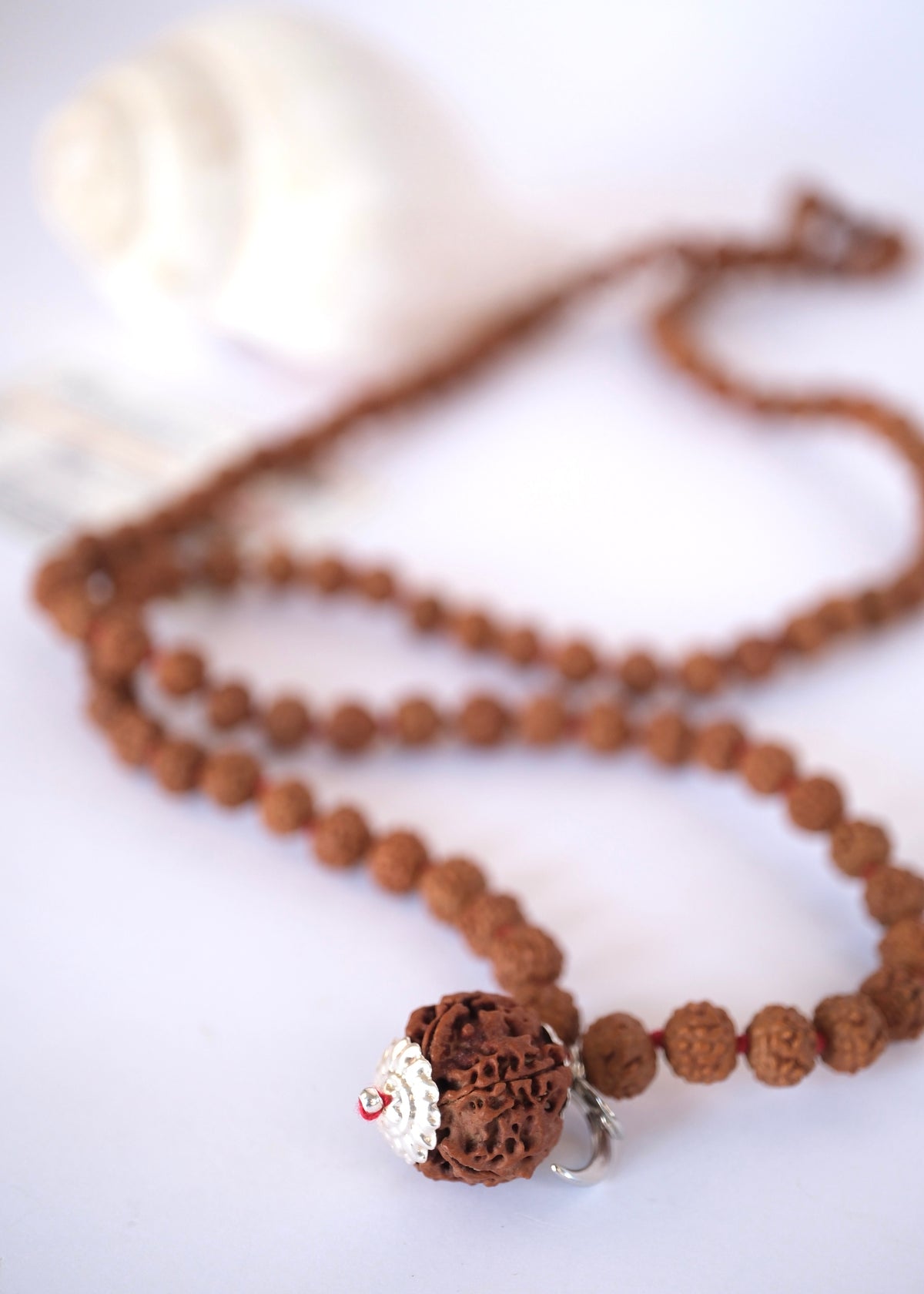 Intricate sterling silver cap securing the sacred guru bead on a genuine Nepal Rudraksha mala.