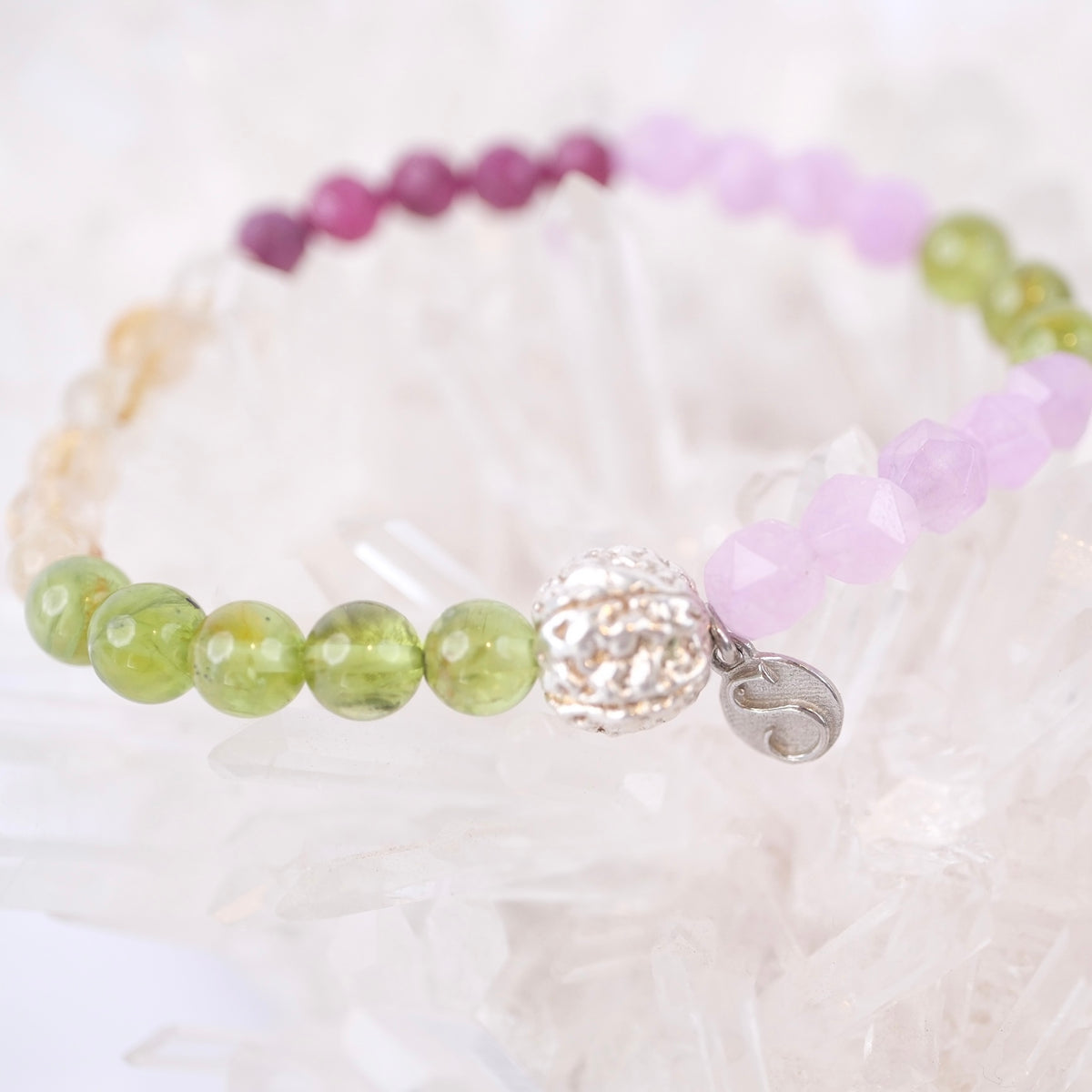Beaded bracelet with a silver clasp on a white shell background