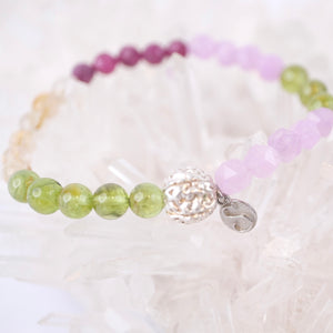 Beaded bracelet with a silver clasp on a white shell background