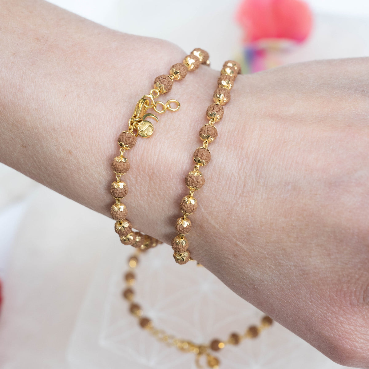 a gold bracelet with a rudraksh